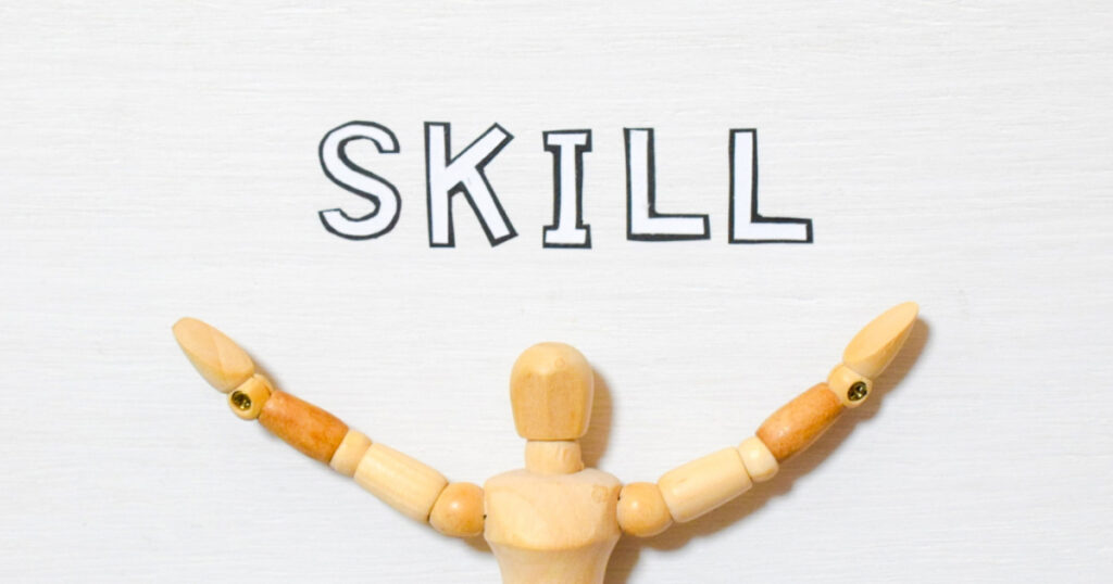 スキル習得をイメージした木製人形とSKILLの文字